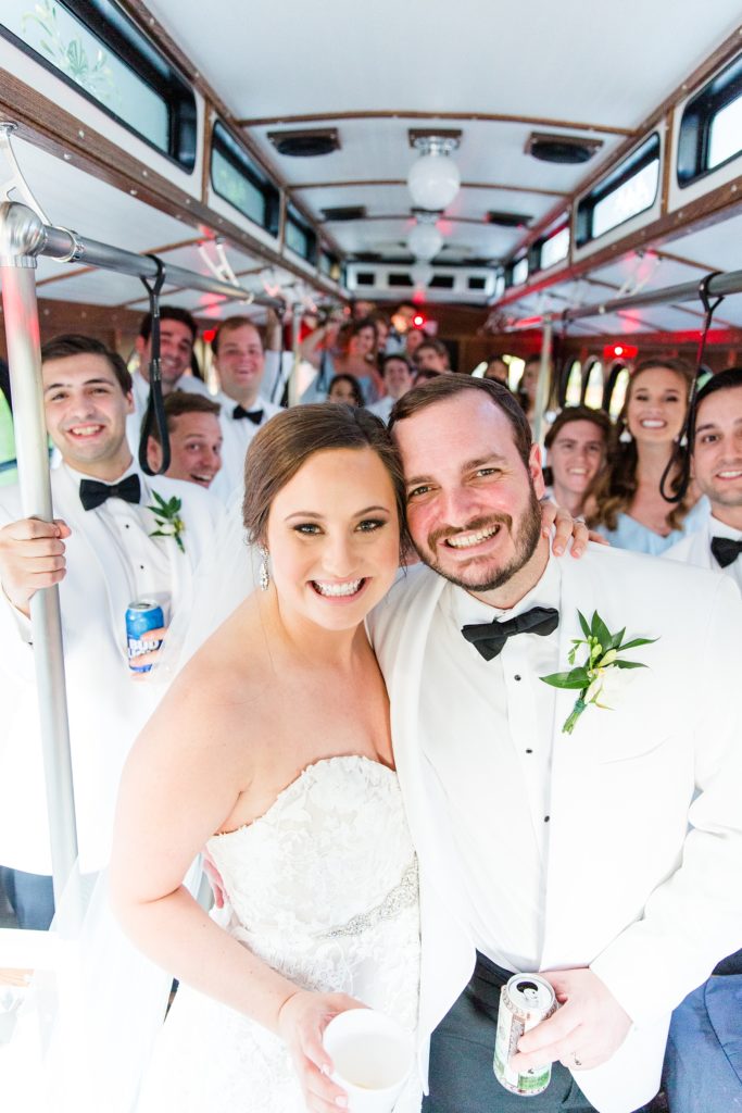 Bride and groom on trolley with bridal party