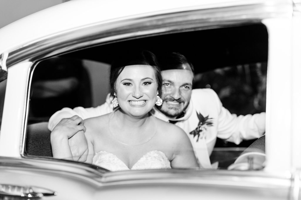 Bride and Groom leave reception in classic car