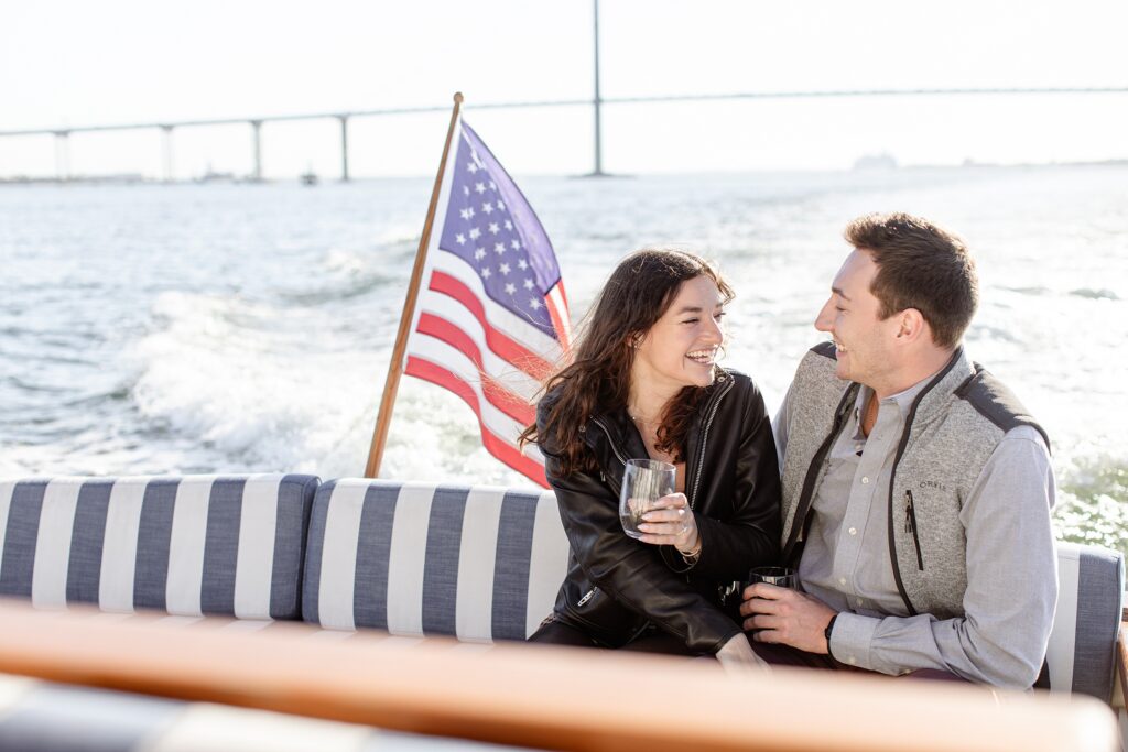 Engaged couple on boat in Charleston, South Carolina with Ravenel Bridge in background; Daniel Island Yacht Club